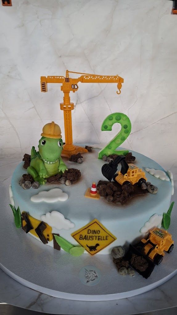Kindertorte mit modelliertem Dinosaurier, Baustellenfahrzeugen und Zahl Zwei
