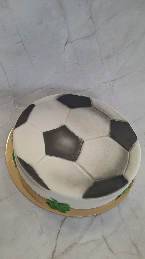 Torte in Form eines Fußballs mit schwarzen und weißen Fondantfeldern